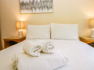 A bedroom with a bed and towels stacked at Dogwood Timber Lodge in Keswick