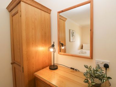 A bedroom with a lamp and mirror at Dogwood Timber Lodge in Keswick