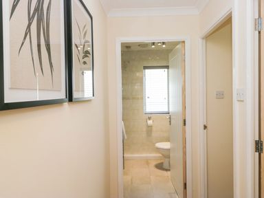A bathroom with a toilet and framed artwork at Dogwood Timber Lodge in Keswick
