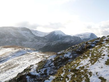A snowy landscape with mountains and people walking at Dogwood Timber Lodge in Keswick