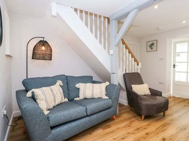 A living room with a sofa and armchair at Riverside Cottage No 4 in Keswick
