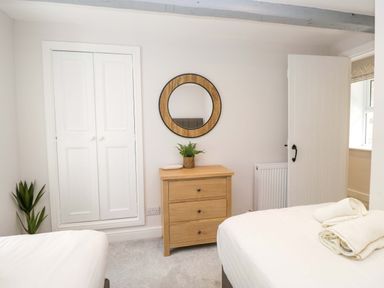 A bedroom with a dresser and mirror at Riverside Cottage No 4, Keswick