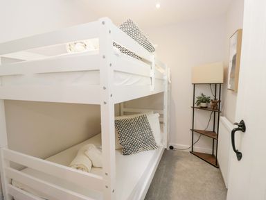 A bedroom with bunk beds and a lamp at Riverside Cottage No 4 in Keswick