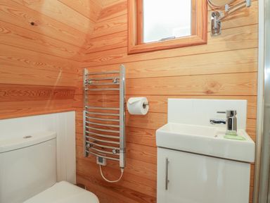 A bathroom with a toilet sink towel rail and window at Pod No 6 Keswick