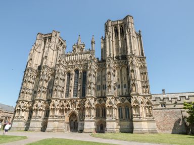 A large gothic cathedral with detailed stone carvings and tall towers under a clear sky