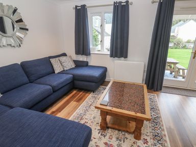 A living room with a sofa and coffee table at Chellowdene Cottage in Falmouth