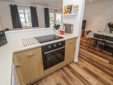 A kitchen with cabinets and an oven at Chellowdene Cottage in Falmouth