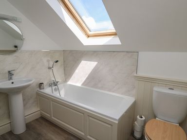 A bathroom with a bathtub a sink a toilet and a skylight window at The Clove in Poyston Cross near Haverfordwest