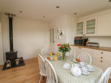A kitchen dining area with a table set with cups croissants and orange juice at Lavender Lodge in Haverfordwest