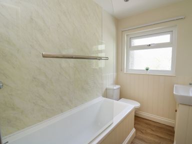 A bathroom with a bathtub toilet sink and window at Lavender Lodge in Haverfordwest