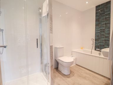 A bathroom with a shower enclosure toilet bathtub and sink at Little Chapter in Walberswick