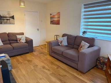 A living room with two sofas and wall art at Jacuma in Rhosneigr