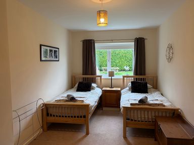 A bedroom with two beds and a window at Jacuma in Rhosneigr