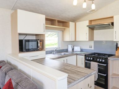 A kitchen area with microwave kettle toaster stove and countertop at Swinside in Lorton