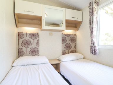A bedroom with two single beds a window and storage cabinets at Swinside in Lorton