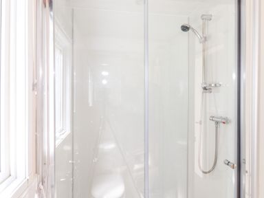 A shower area with a glass door a showerhead and controls in a bathroom at Whiteside in Lorton