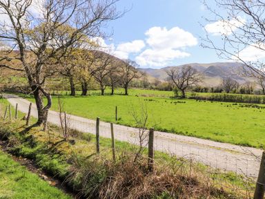 A rural landscape with a dirt road a wire fence leafless trees and hills in the background at Whiteside in Lorton
