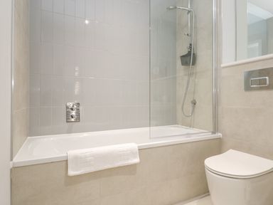 A bathroom with a bathtub shower combination and a toilet at Sebastians View in Falmouth