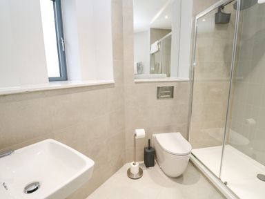 A bathroom with a sink toilet and shower with glass door at Sebastians View in Falmouth