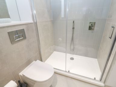 A bathroom with a toilet and a glass-enclosed shower at Sebastians View in Falmouth
