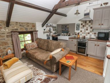 A kitchen with a sofa and dining area at Coach House Haverfordwest near Broad Haven