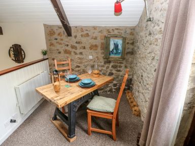 A dining room with a wooden table and chairs at Coach House Haverfordwest near Broad Haven