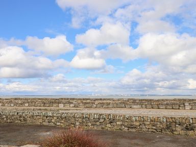 A view of the sea with stone walls and a cloudy sky at Little Beach in Seaview
