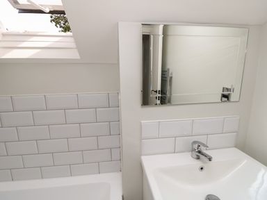 A bathroom with a white sink faucet and mirror above the sink at Chine Heights in Bournemouth