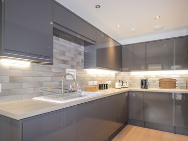 A kitchen with grey cabinets countertop appliances and a sink at Ben Luna Lodge in Drumnadrochit Loch Ness