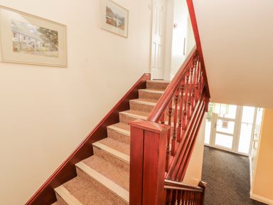A staircase with framed pictures on the wall at Flat 17 in Keswick