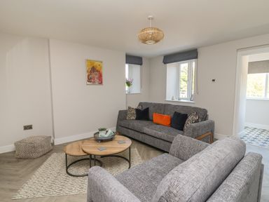 A living room with two gray sofas and a wooden coffee table at Rhiwmynach in Pontarfynach near Aberystwyth