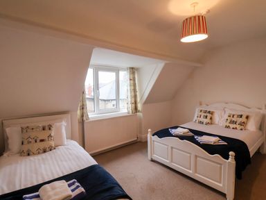 A bedroom with a double bed and a single bed under a window at South Bay Beach House in Bridlington