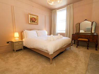 A bedroom with a bed and a dressing table at 123 On The Sea – Victoria’s Place, Weymouth