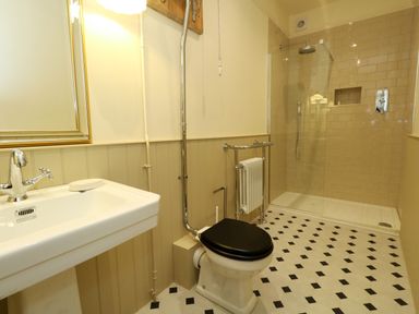 A bathroom with a sink, toilet, shower, and radiator at 123 On The Sea – Victoria’s Place Weymouth