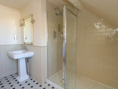 A bathroom with a shower and wash basin at 123 On The Sea – The Eaves, Weymouth
