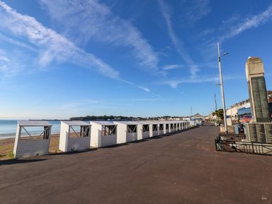 A row of beach huts along the shore at 123 On The Sea – The Eaves Weymouth