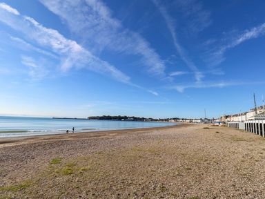 A beach with people walking along the shore at 123 On The Sea – The Eaves Weymouth