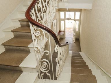 A staircase leading to a hallway with a door at 123 On The Sea – The Eaves, Weymouth