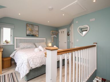A bedroom with a bed and a heart-shaped mirror on the wall at Blue Waters in Weymouth