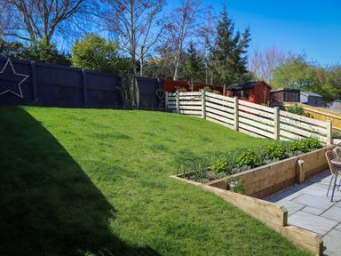 A garden with grass and a flower bed at The Nightingale in Weymouth
