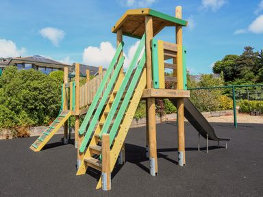 An outdoor children's playground with a wooden climbing structure and slide at 5 Court Cottage Hillfield Village Dartmouth