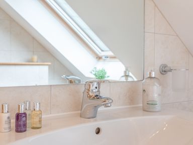 A bathroom sink with a faucet and toiletries on the counter at 5 Court Cottage Hillfield Village in Dartmouth