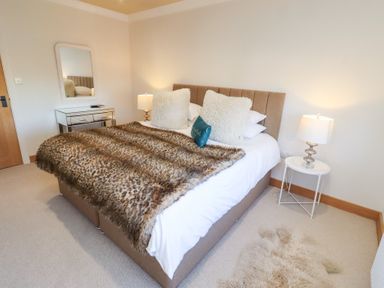 A bedroom with a bed and bedside tables at Nene's Nest in Alnwick
