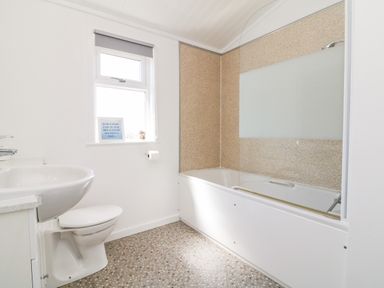 A bathroom with a bathtub shower sink toilet and a window at Mojo Mullacott near Ilfracombe