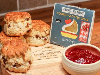 Scones with raisins clotted cream and strawberry jam on a wooden board at Inny Brook Cottage in Davidstow near Camelford