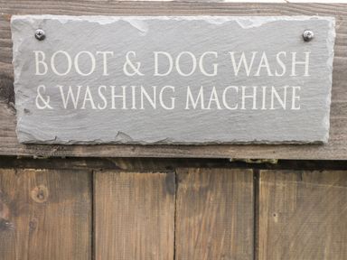 A slate sign with the text Boot and Dog Wash and Washing Machine mounted on wood