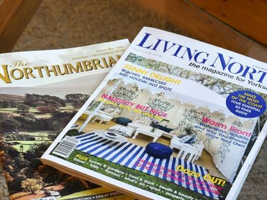 Magazines on a glass table at The Loft (Amble) in Amble