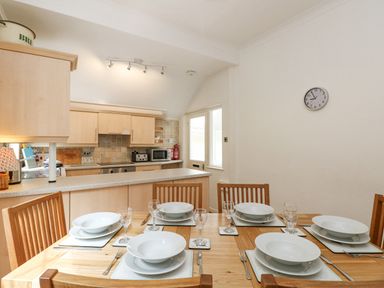 A dining table set for six with bowls plates glasses and cutlery in a kitchen at Brantfell Lodge in Bowness-On-Windermere
