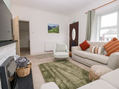 A living room with a sofa and armchair at 3 Nixon Terrace Broughton Moor near Maryport