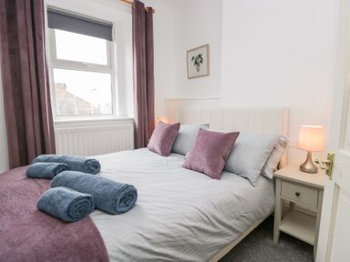 A bedroom with a bed and nightstand at 3 Nixon Terrace in Broughton Moor near Maryport
